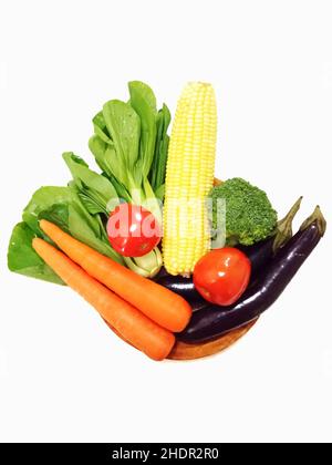 Raw vegetables on a wooden plate on a white table Stock Photo