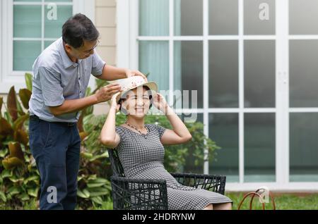Asian middle aged couple sitting and relax in backyard Stock Photo