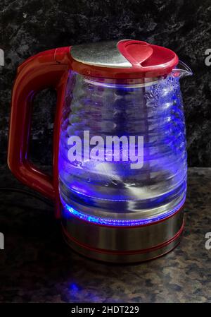 Glass electric kettle with blue LED lighting close-up. Stock Photo