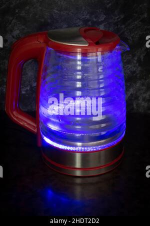 Glass electric kettle with blue LED lighting close-up. Stock Photo