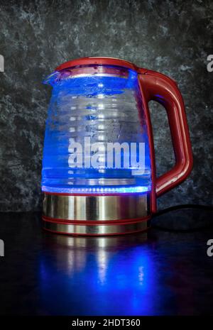 Glass electric kettle with blue LED lighting close-up. Stock Photo