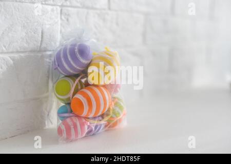 multi-colored chicken eggs in bag mesh on white background. easter Stock Photo