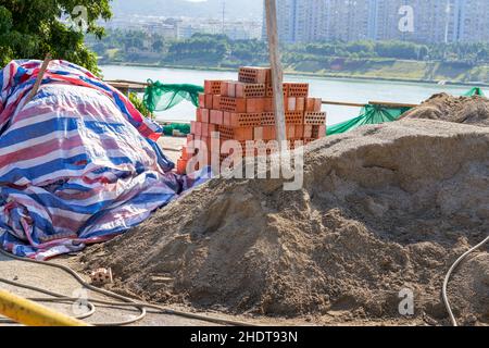 Pile of cement and bricks at roadside construction site Stock Photo