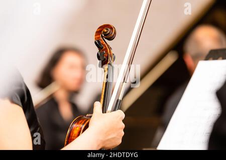 Symphony orchestra on stage, hands playing violin Stock Photo