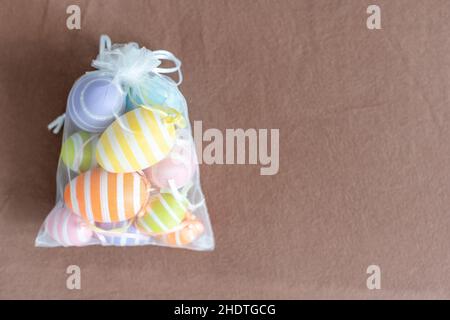 multi-colored chicken eggs in bag mesh on background. easter Stock Photo
