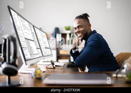 African American Coder Using Computer At Desk. Web Developer Stock Photo