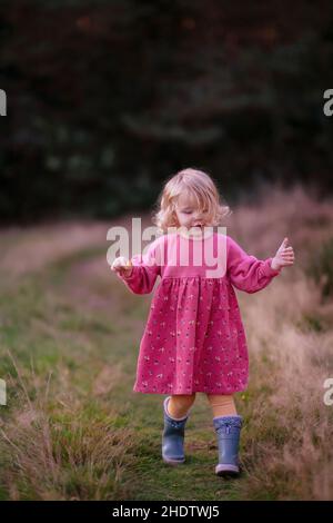 Vertical shot of the cute little girl in the park. Stock Photo