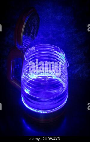 Glass electric kettle with blue LED lighting close-up. Stock Photo