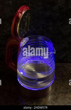Glass electric kettle with blue LED lighting close-up. Stock Photo