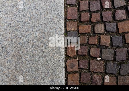 perpendicular view of a pavement of porphyry tiles and stone slabs in a medieval Italian square Stock Photo