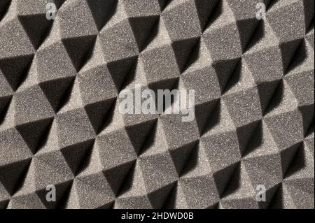 perpendicular view of a gray pyramidal sound-absorbing foam panel, shadows at 45 degrees Stock Photo