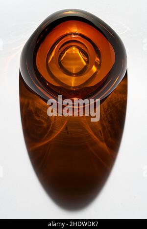 retro style amber glass ashtray dating back to the 60s on a white background with colored obra and reflections Stock Photo