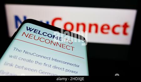 Smartphone with webpage of power transmission project NeuConnect Interconnector on screen in front of logo. Focus on top-left of phone display. Stock Photo