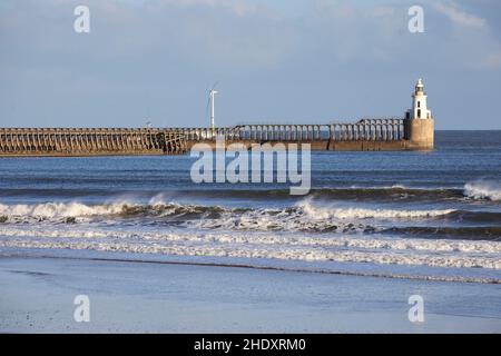 Blyth Harbour Lighthouse in North Tyneside, Tyne & Wear, England Dog walker on Blyth Beach Stock Photo