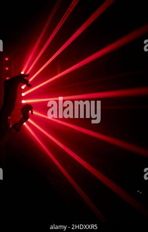 Bright red neon laser lights illuminate the darkness creating lines and triangle shapes in sci-fi effect Stock Photo