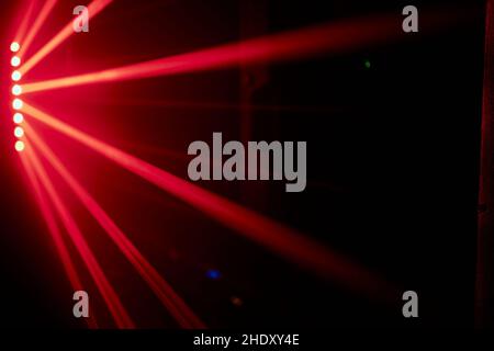 Bright red neon laser lights illuminate the darkness creating lines and triangle shapes in sci-fi effect Stock Photo