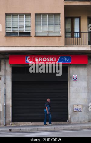 Palma, Mallorca, Spain - October 8th 2021: Man with mask passes closed Eroski supermarket Stock Photo