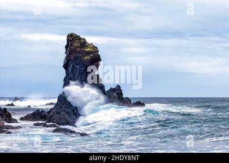 Rough seas send waves crashing into a basalt sea stack at Djupalonssandur beach, Snaefellsnes peninsula, Iceland. Stock Photo