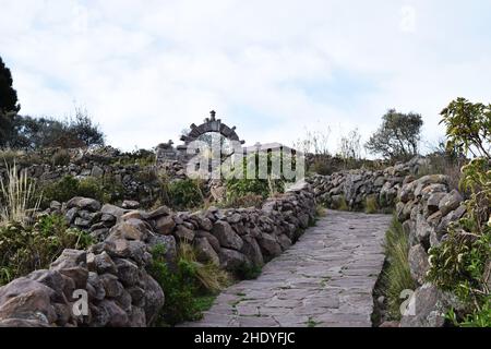 Trail and footpath along archaeological remains and old ruins of stones on Taquile island, located on the Peruvian side of Lake Titicaca in Peru. Stock Photo