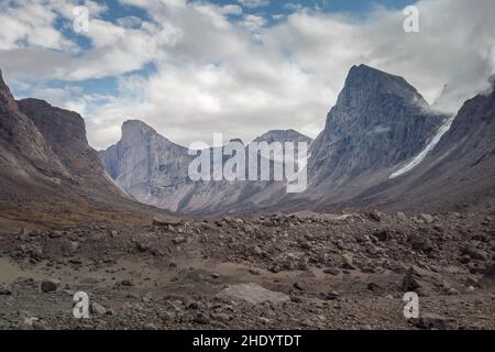 Southwest face of Mt. Thor, highest vertical cliff on Earth, on a day of arctic summer. HIking in wild, remote arctic valley of Akshayuk Pass, Baffin Stock Photo