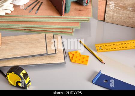 Laminate flooring sheets and tools on gray table. Elevated view. Horizontal composition. Stock Photo