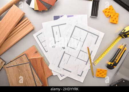 Work table of a decorator with samples of wood materials and tools for interior project. Top view. Stock Photo