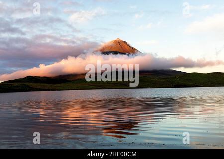 Lake surface and first sunlight falling onto Ponta da Pico, on Pico Island, Lagoa do Capitão, Azores, Portugal Stock Photo