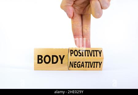 Body positivity or negativity symbol. Psychologist turns cubes, changes words body negativity to body positivity. White background, copy space. Psycho Stock Photo