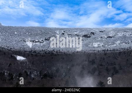 Ski mountain and paths covered in fresh snow and pine trees. Stock Photo