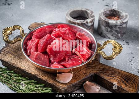 Uncooked Raw diced beef veal meat for stew in skillet. Gray background. Top view Stock Photo