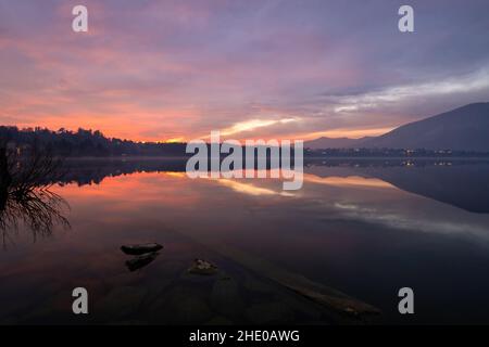 Sunset over the lake with beautiful sky and landscape reflections, Como, Lombardy, Italy Stock Photo