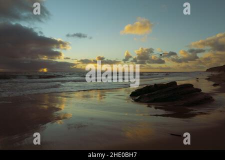 Low angle view of sunset behind clouds from beach Stock Photo