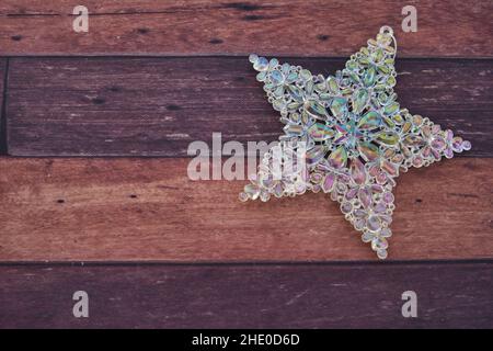 Shiny Christmas silver star on a wooden table Stock Photo