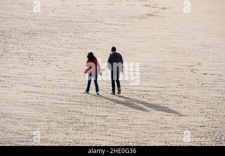 couple walking on the sand on the beach Stock Photo