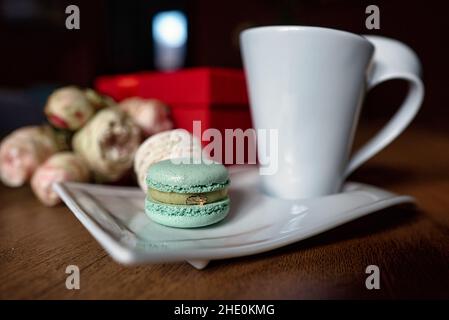Macaron and cup of coffee on wooden background. Stock Photo