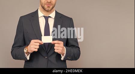 cropped businessman hold credit card with copy space on grey background, banking Stock Photo