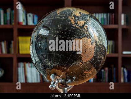 Chiang Rai,Thailand - Sep 06, 2020 : Replica globe on the background of bookshelves in library. Selective focus. Stock Photo