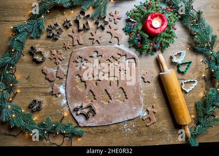Shortbread dough for gingerbread cookies rolled on the wooden board. Cutting out star shaped cookies Stock Photo