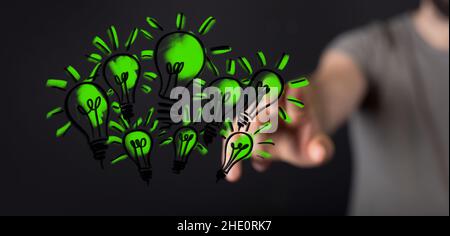 Male pointing to an illustration of green light bulbs - eco-friendly business Stock Photo