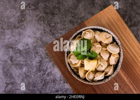 Top view of traditional russian dish pelmeni or dumplings with meat and butter. Stock Photo