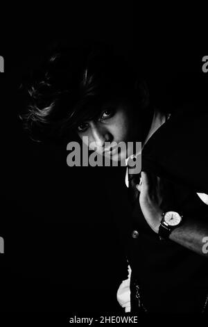 Grayscale shot of an enigmatic man posing in classic clothes and accessories Stock Photo