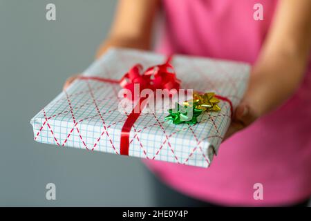 Woman hands a wrapped present- selective focus Stock Photo