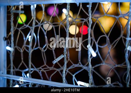 Some white decoration light bulbs web close up still with some colourful blurred spots on a black background Stock Photo