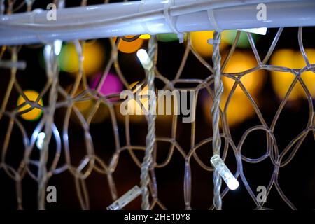 Some white decoration light bulbs web close up still with some colourful blurred spots on a black background Stock Photo
