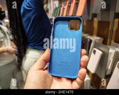 Paris, France - Sep 24, 2021: POV male hand holding blue silicone protection case of iPhone 13 Pro at the Apple Store as latest new 5G iPhone 13, 13 Pro, new iPad and iPad mini go on sale - new camera new bionic CPU Stock Photo
