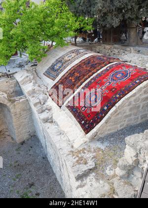 Traditional Azeri carpets for sale at vintage flea market presentation of colorful Azerbaijan motives in central Baku Stock Photo
