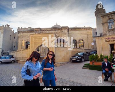 Baku, Azerbaijan - May 1, 2019: Young beautiful girls walking in front of Icheri Sheher traditional market Stock Photo