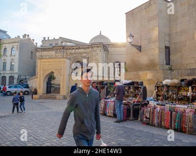 Baku, Azerbaijan - May 1, 2019: Icheri Sheher traditional market with people curious boy walking in front of camera Stock Photo