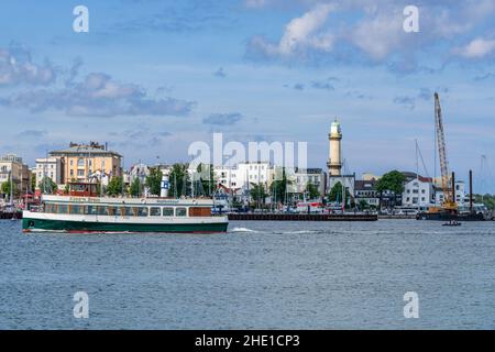 Rostock, Mecklenburg-Western Pomerania, Germany - June 14, 2020: View from Hohe Duene towards Warnemuende with the lighthouse and a harbour cruise shi Stock Photo