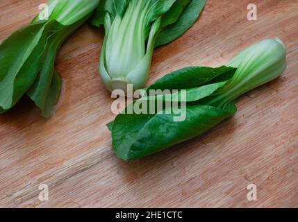 Freshly washed raw Bok choy on wooden cutting board Stock Photo